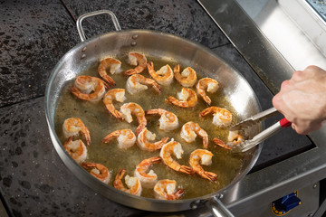 the process of frying shrimp in a frying pan
