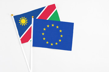 European Union and Namibia stick flags on white background. High quality fabric, miniature national flag. Peaceful global concept.White floor for copy space.
