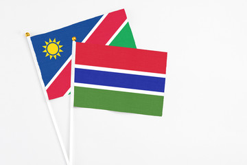 Gambia and Namibia stick flags on white background. High quality fabric, miniature national flag. Peaceful global concept.White floor for copy space.