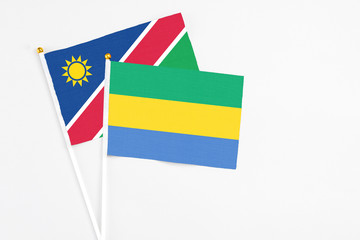 Gabon and Namibia stick flags on white background. High quality fabric, miniature national flag. Peaceful global concept.White floor for copy space.