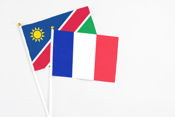 Fototapeta na wymiar France and Namibia stick flags on white background. High quality fabric, miniature national flag. Peaceful global concept.White floor for copy space.