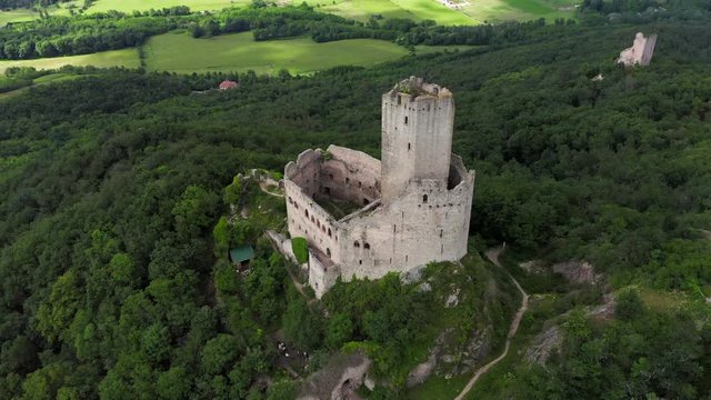 Rising aerial circle of an ancient castle in France on a cloudy day. Shot end tilted down to the castle.