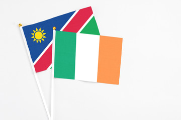 Ireland and Namibia stick flags on white background. High quality fabric, miniature national flag. Peaceful global concept.White floor for copy space.