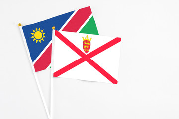 Jersey and Namibia stick flags on white background. High quality fabric, miniature national flag. Peaceful global concept.White floor for copy space.