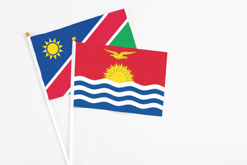 Kiribati and Namibia stick flags on white background. High quality fabric, miniature national flag. Peaceful global concept.White floor for copy space.
