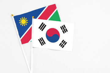 South Korea and Namibia stick flags on white background. High quality fabric, miniature national flag. Peaceful global concept.White floor for copy space.