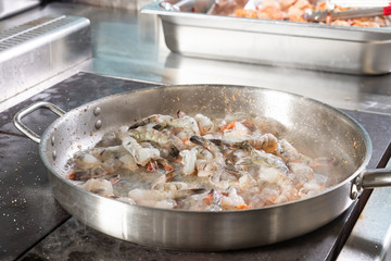 the process of frying shrimp in a frying pan