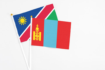 Mongolia and Namibia stick flags on white background. High quality fabric, miniature national flag. Peaceful global concept.White floor for copy space.
