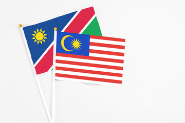 Malaysia and Namibia stick flags on white background. High quality fabric, miniature national flag. Peaceful global concept.White floor for copy space.