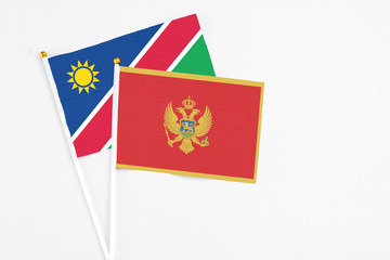 Montenegro and Namibia stick flags on white background. High quality fabric, miniature national flag. Peaceful global concept.White floor for copy space.
