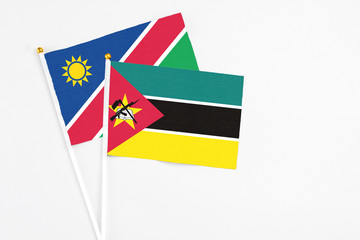 Mozambique and Namibia stick flags on white background. High quality fabric, miniature national flag. Peaceful global concept.White floor for copy space.