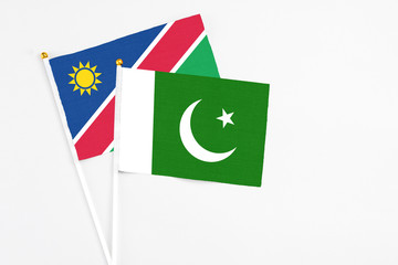 Pakistan and Namibia stick flags on white background. High quality fabric, miniature national flag. Peaceful global concept.White floor for copy space.