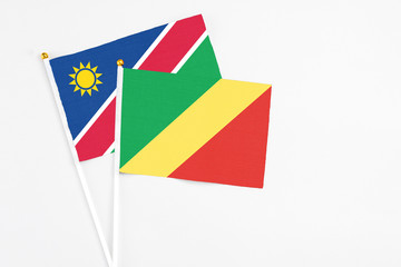 Republic Of The Congo and Namibia stick flags on white background. High quality fabric, miniature national flag. Peaceful global concept.White floor for copy space.