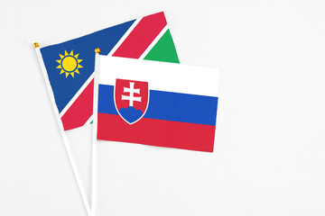 Slovakia and Namibia stick flags on white background. High quality fabric, miniature national flag. Peaceful global concept.White floor for copy space.