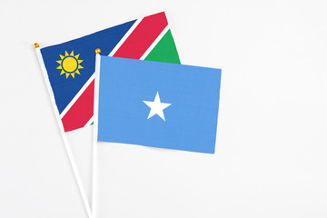 Somalia and Namibia stick flags on white background. High quality fabric, miniature national flag. Peaceful global concept.White floor for copy space.