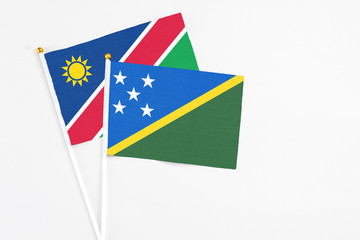 Solomon Islands and Namibia stick flags on white background. High quality fabric, miniature...