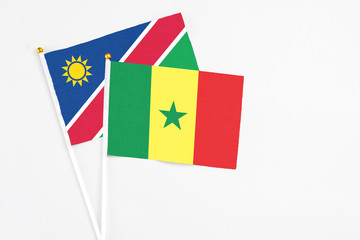 Senegal and Namibia stick flags on white background. High quality fabric, miniature national flag. Peaceful global concept.White floor for copy space.