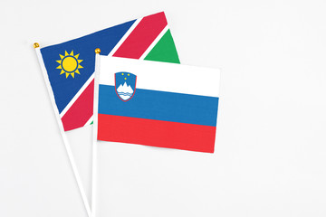 Slovenia and Namibia stick flags on white background. High quality fabric, miniature national flag. Peaceful global concept.White floor for copy space.