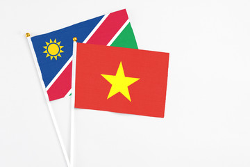 Vietnam and Namibia stick flags on white background. High quality fabric, miniature national flag. Peaceful global concept.White floor for copy space.