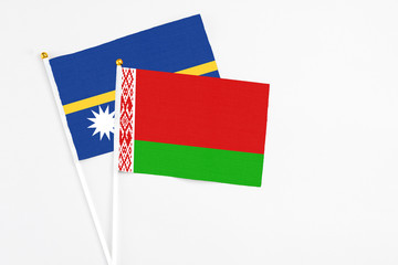 Belarus and Nauru stick flags on white background. High quality fabric, miniature national flag. Peaceful global concept.White floor for copy space.