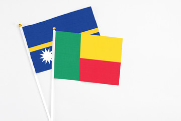Benin and Nauru stick flags on white background. High quality fabric, miniature national flag. Peaceful global concept.White floor for copy space.