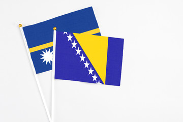 Bosnia Herzegovina and Nauru stick flags on white background. High quality fabric, miniature...