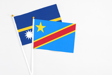 Congo and Nauru stick flags on white background. High quality fabric, miniature national flag. Peaceful global concept.White floor for copy space.