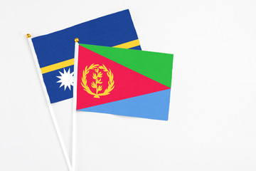 Eritrea and Nauru stick flags on white background. High quality fabric, miniature national flag. Peaceful global concept.White floor for copy space.