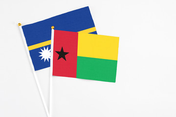 Guinea Bissau and Nauru stick flags on white background. High quality fabric, miniature national flag. Peaceful global concept.White floor for copy space.