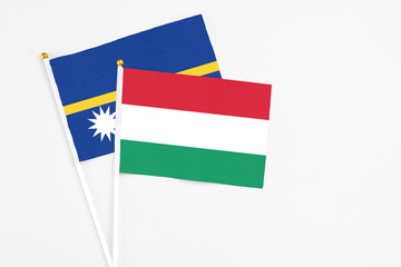 Hungary and Nauru stick flags on white background. High quality fabric, miniature national flag. Peaceful global concept.White floor for copy space.