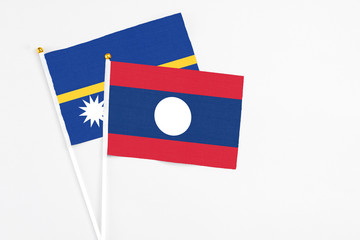 Laos and Nauru stick flags on white background. High quality fabric, miniature national flag. Peaceful global concept.White floor for copy space.