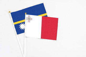 Malta and Nauru stick flags on white background. High quality fabric, miniature national flag. Peaceful global concept.White floor for copy space.