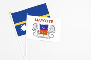 Mayotte and Nauru stick flags on white background. High quality fabric, miniature national flag. Peaceful global concept.White floor for copy space.