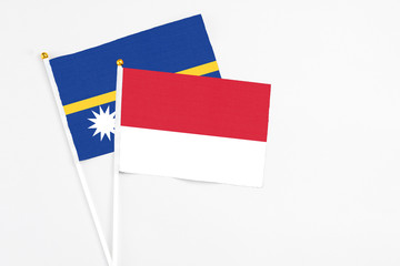 Monaco and Nauru stick flags on white background. High quality fabric, miniature national flag. Peaceful global concept.White floor for copy space.