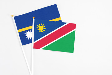 Namibia and Nauru stick flags on white background. High quality fabric, miniature national flag. Peaceful global concept.White floor for copy space.