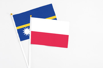Poland and Nauru stick flags on white background. High quality fabric, miniature national flag. Peaceful global concept.White floor for copy space.