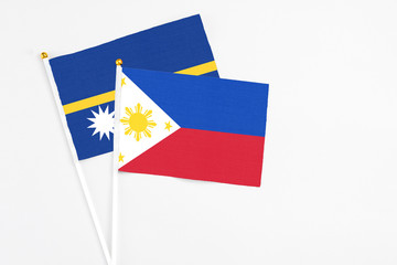 Philippines and Nauru stick flags on white background. High quality fabric, miniature national flag. Peaceful global concept.White floor for copy space.