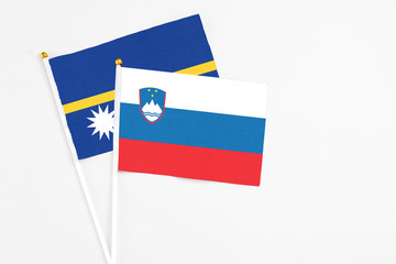 Slovenia and Nauru stick flags on white background. High quality fabric, miniature national flag. Peaceful global concept.White floor for copy space.