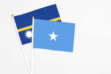 Somalia and Nauru stick flags on white background. High quality fabric, miniature national flag. Peaceful global concept.White floor for copy space.