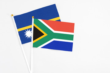 South Africa and Nauru stick flags on white background. High quality fabric, miniature national flag. Peaceful global concept.White floor for copy space.