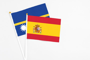 Spain and Nauru stick flags on white background. High quality fabric, miniature national flag. Peaceful global concept.White floor for copy space.