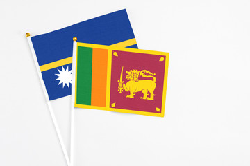 Sri Lanka and Nauru stick flags on white background. High quality fabric, miniature national flag. Peaceful global concept.White floor for copy space.