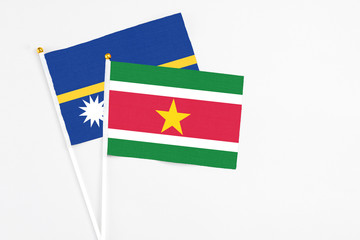 Suriname and Nauru stick flags on white background. High quality fabric, miniature national flag....
