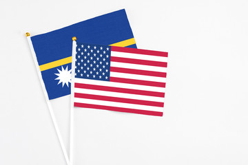 United States and Nauru stick flags on white background. High quality fabric, miniature national flag. Peaceful global concept.White floor for copy space.