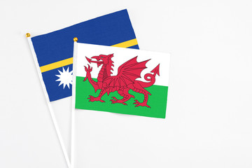 Wales and Nauru stick flags on white background. High quality fabric, miniature national flag. Peaceful global concept.White floor for copy space.