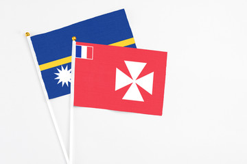 Wallis And Futuna and Nauru stick flags on white background. High quality fabric, miniature national flag. Peaceful global concept.White floor for copy space.