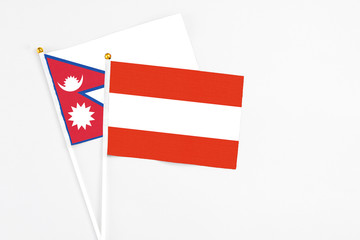 Austria and Nepal stick flags on white background. High quality fabric, miniature national flag. Peaceful global concept.White floor for copy space.