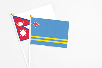Aruba and Nepal stick flags on white background. High quality fabric, miniature national flag. Peaceful global concept.White floor for copy space.