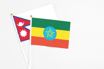 Ethiopia and Nepal stick flags on white background. High quality fabric, miniature national flag. Peaceful global concept.White floor for copy space.
