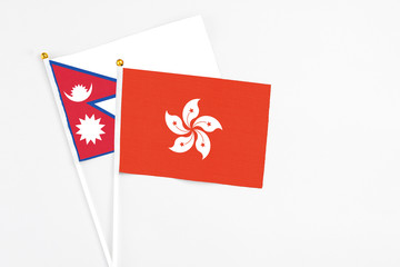 Hong Kong and Nepal stick flags on white background. High quality fabric, miniature national flag. Peaceful global concept.White floor for copy space.